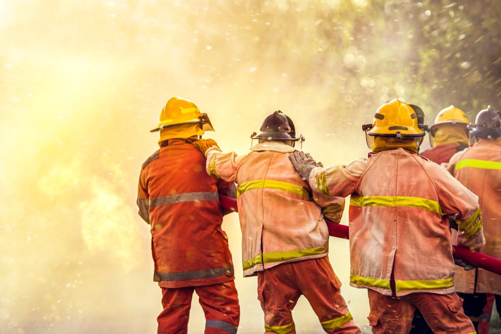 Firefighter,Spraying,Water,To,Fire,For,Heat,Protection,,Team,Fireman
